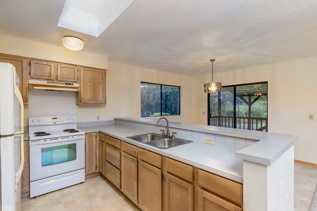 17-4018 Kuaaina Road, Unit 105 Kurtistown, HI 96749 - Photo 4 of 22 a kitchen with stainless steel appliances a sink stove and cabinets