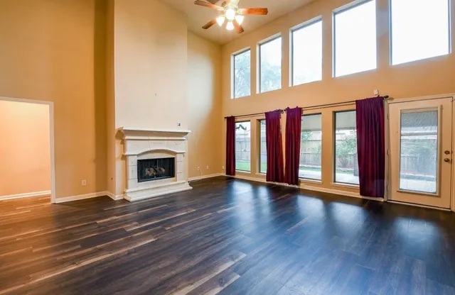 a view of an empty room with window and fireplace