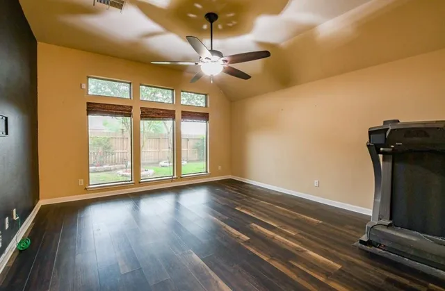 a view of room with wooden floor fan and window