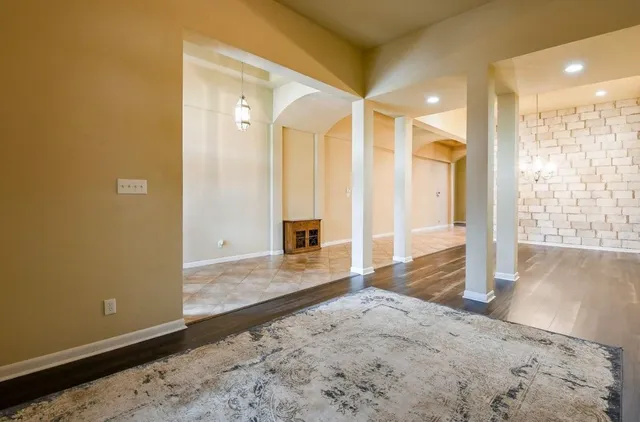 a view of a hallway with wooden floor and living room