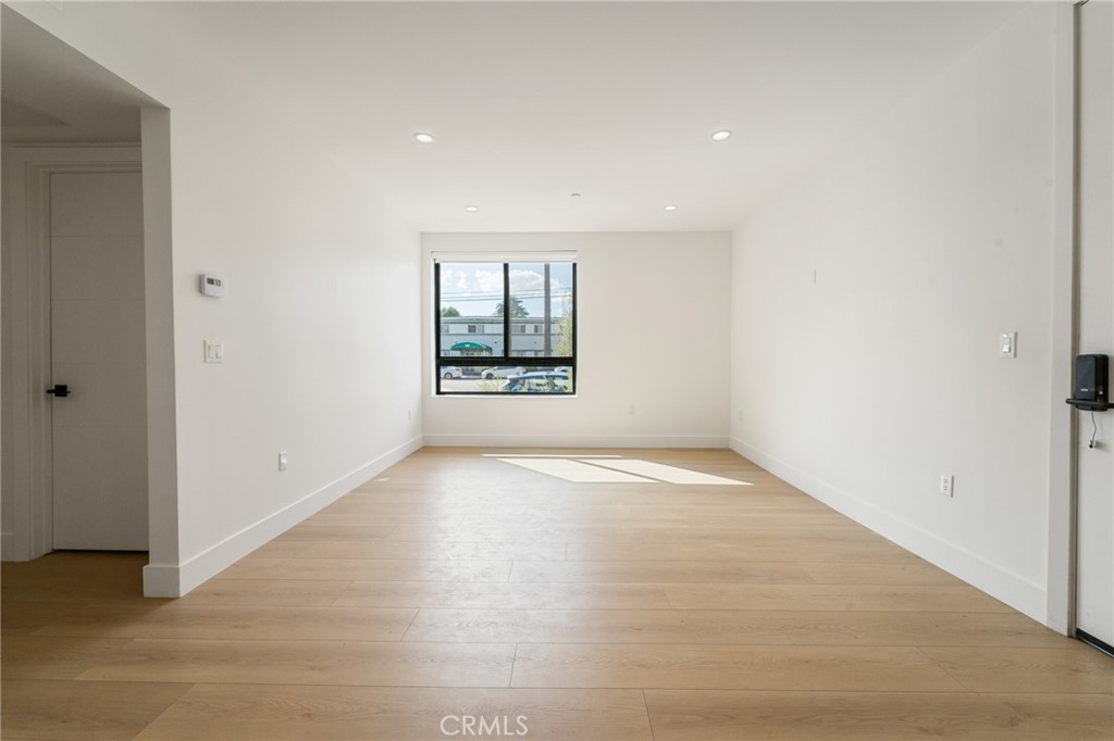 7510 Sepulveda Boulevard, Unit 101 Van Nuys, CA 91405 - Photo 11 of 16 an empty room with a window and wooden floor