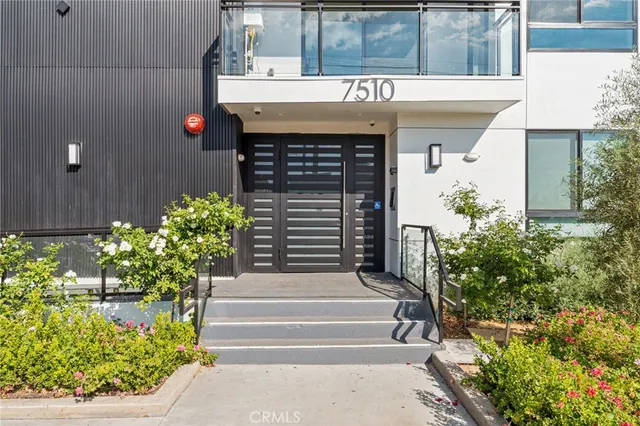 a front view of a house with plants