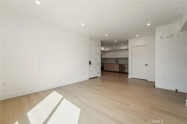 a view of an empty room with a kitchen