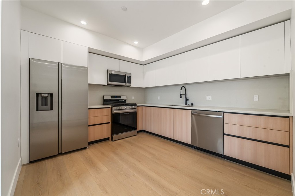 7510 Sepulveda Boulevard, Unit 101 Van Nuys, CA 91405 - Photo 9 of 16 a kitchen with granite countertop a refrigerator and a sink