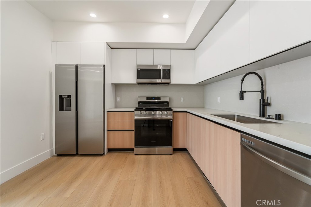 7510 Sepulveda Boulevard, Unit 101 Van Nuys, CA 91405 - Photo 10 of 16 a kitchen with a refrigerator and a sink