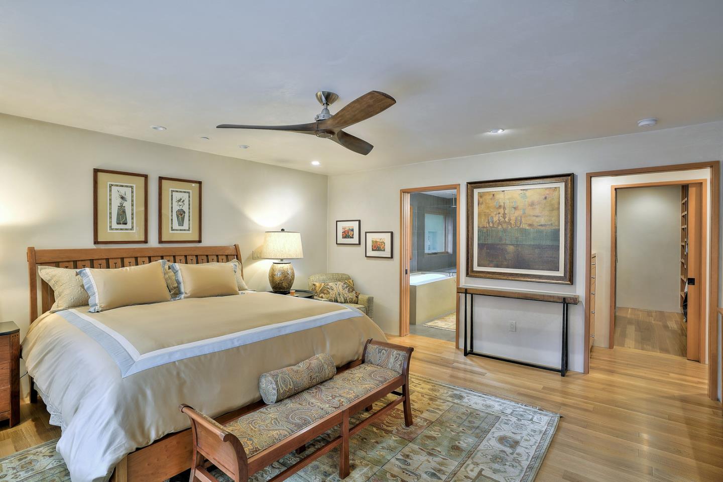 24651 Cabrillo Street Carmel, CA 93923 - Photo 16 of 42 a bedroom with a bed and a chandelier