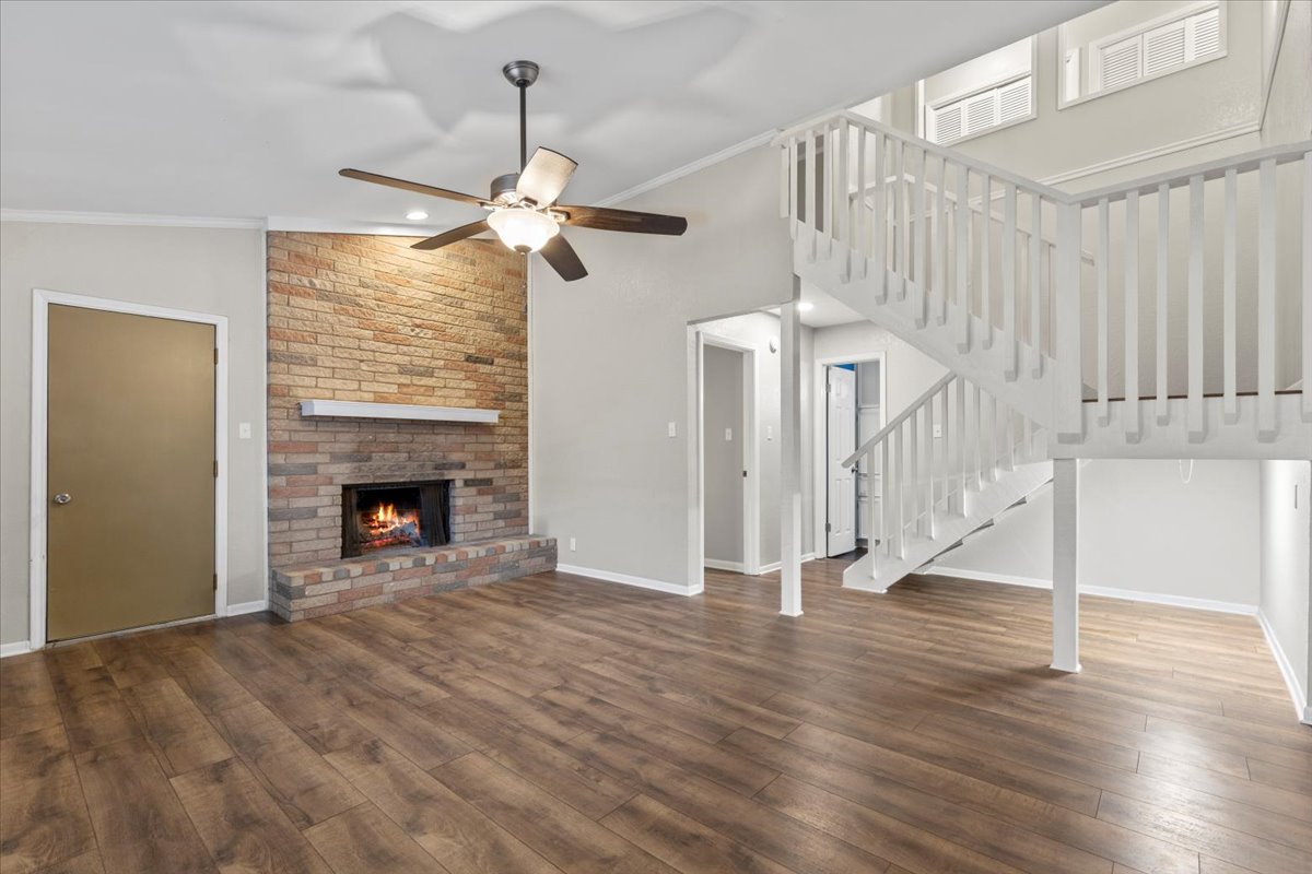 201 East Noton Street, Unit 104 Pflugerville, TX 78660 - Photo 11 of 35 a view of an empty room with wooden floor fireplace and a window