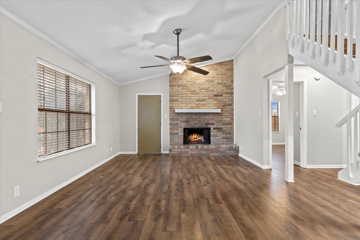 201 East Noton Street, Unit 104 Pflugerville, TX 78660 - Photo 13 of 35 a view of empty room with wooden floor and fireplace