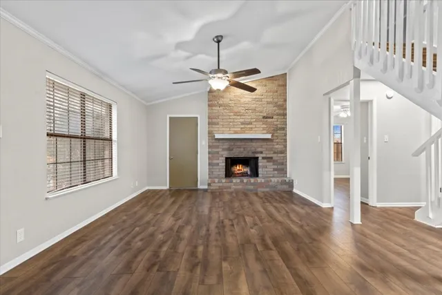 a view of empty room with wooden floor and fireplace