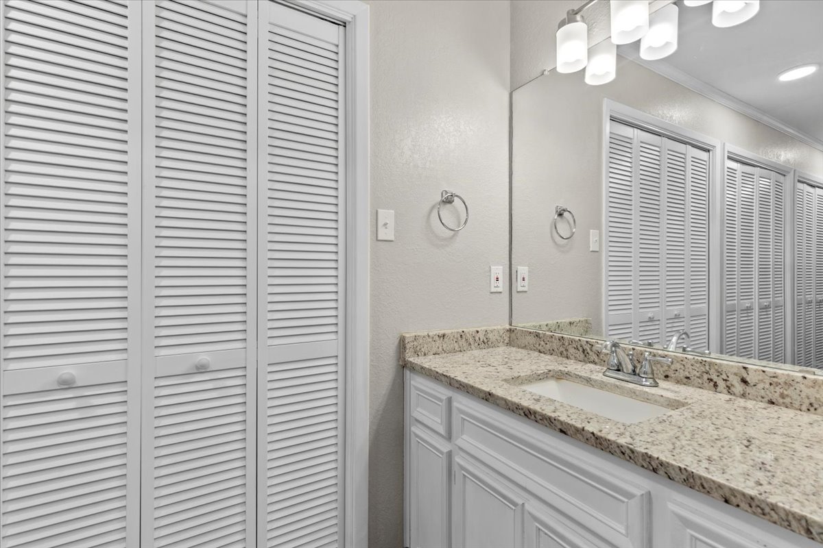 201 East Noton Street, Unit 104 Pflugerville, TX 78660 - Photo 18 of 35 a bathroom with a granite countertop sink and a mirror
