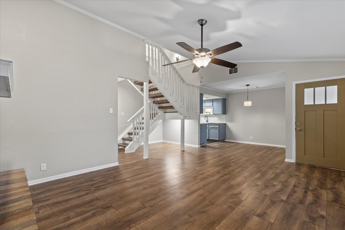 201 East Noton Street, Unit 104 Pflugerville, TX 78660 - Photo 2 of 35 a view of an empty room with wooden floor ceiling fan