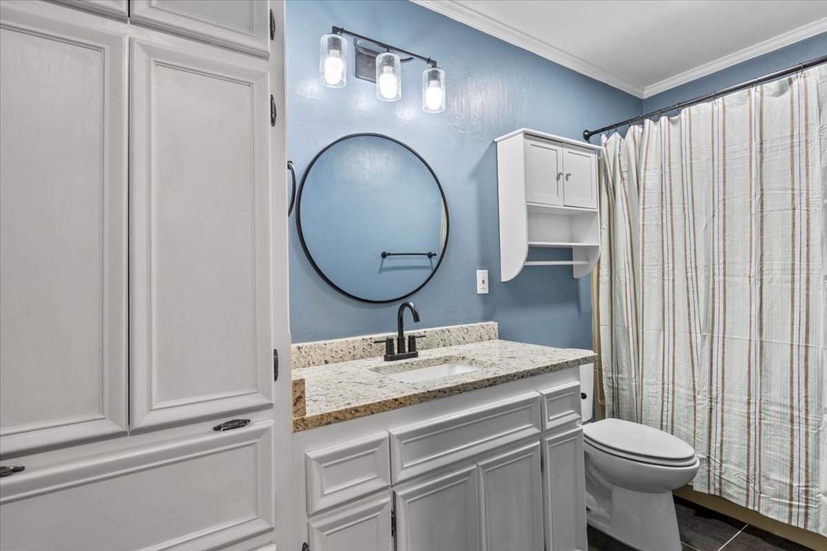 201 East Noton Street, Unit 104 Pflugerville, TX 78660 - Photo 21 of 35 a bathroom with a sink a toilet and a mirror