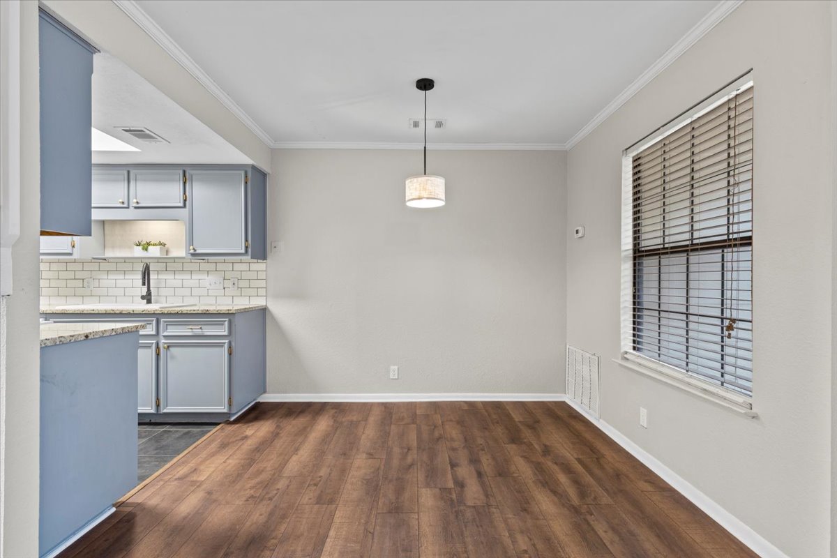 201 East Noton Street, Unit 104 Pflugerville, TX 78660 - Photo 5 of 35 a kitchen with a sink cabinets wooden floor and a window