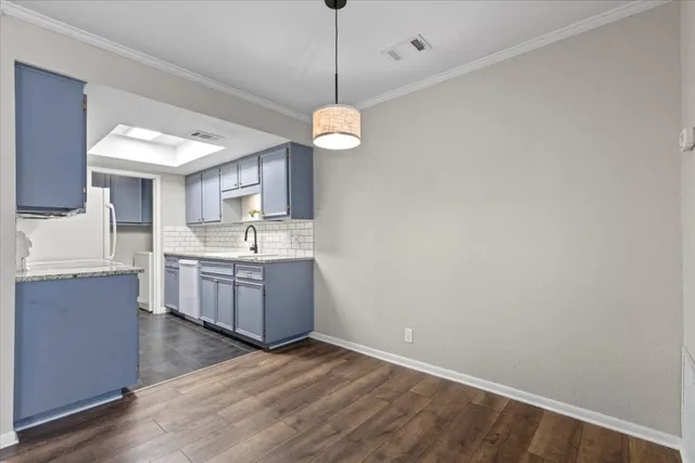 a kitchen with a sink cabinets and wooden floor