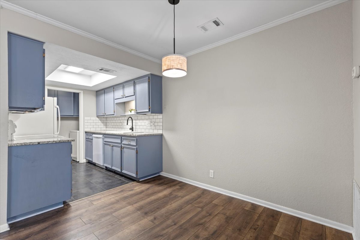 201 East Noton Street, Unit 104 Pflugerville, TX 78660 - Photo 6 of 35 a kitchen with a sink cabinets and wooden floor