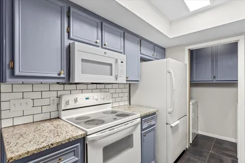 a kitchen with stainless steel appliances granite countertop a refrigerator and a stove