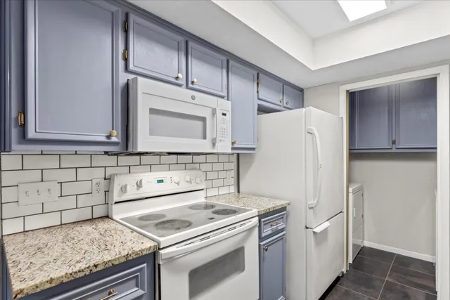 a kitchen with stainless steel appliances granite countertop a refrigerator and a stove