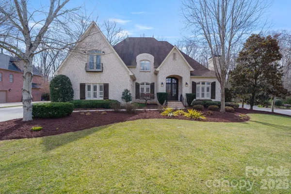 a front view of house with yard and trees around