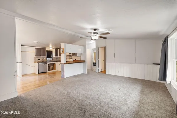 a view of a kitchen with refrigerator and windows