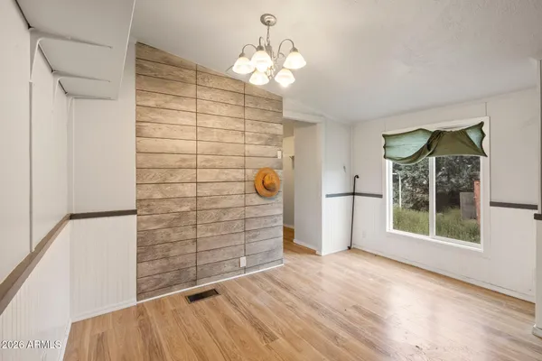 a view of empty room with window and chandelier