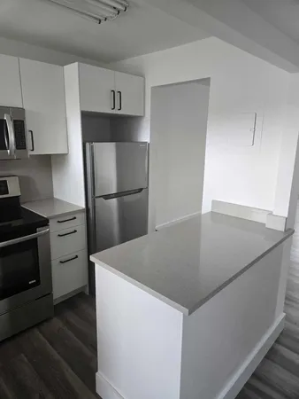 a kitchen with a refrigerator and a stove top oven