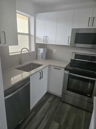 a kitchen with a sink stove and microwave