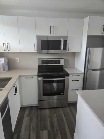 a kitchen with white cabinets and stainless steel appliances