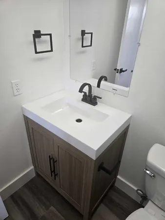 a bathroom with a sink mirror vanity and toilet