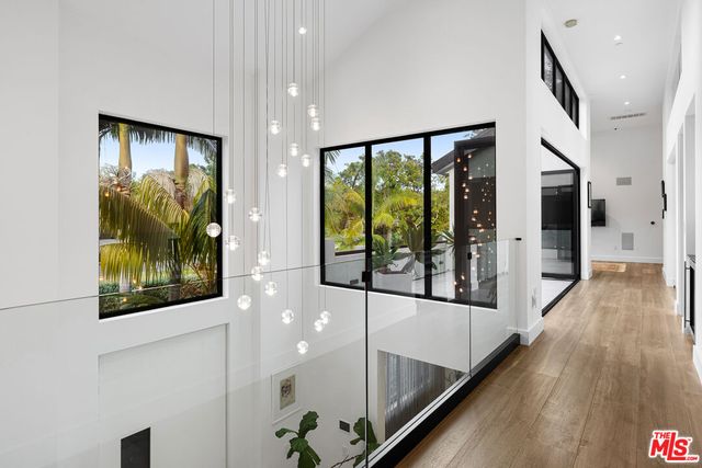 a view of a hallway with wooden floor and windows