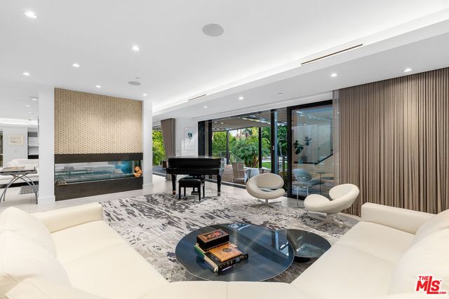 a living room with furniture a floor to ceiling window and wooden floor