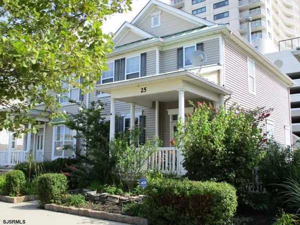 a front view of a house with plants and trees