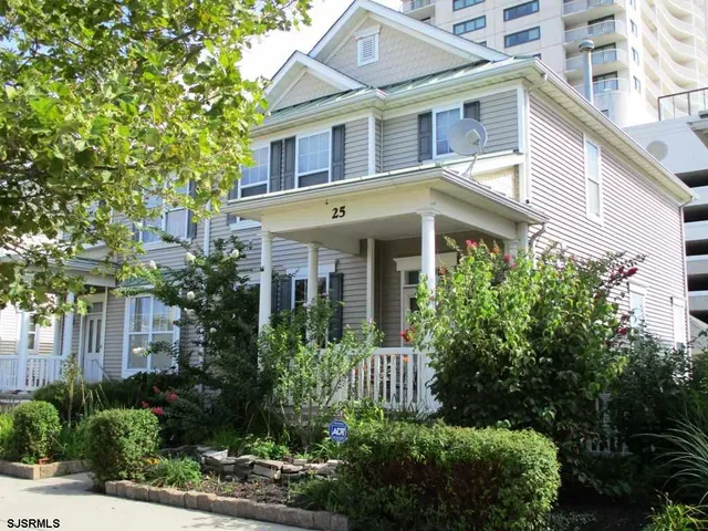 a front view of a house with plants and trees