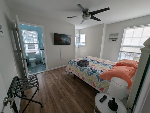 a bedroom with a bed and a flat tv screen on the dresser