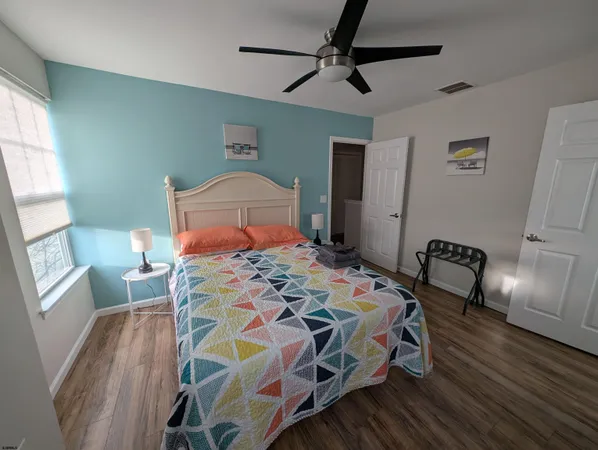a bedroom with a bed a dresser and chair
