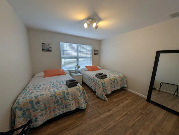 a bedroom with two beds and a window