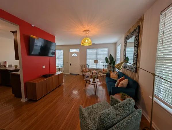 a living room with furniture a flat screen tv and a large window