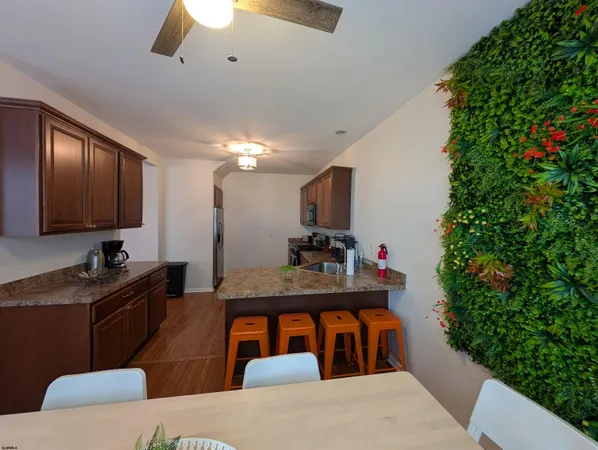 a kitchen with stainless steel appliances granite countertop a stove a sink dishwasher and a microwave oven with wooden floor