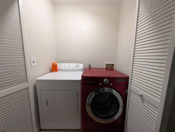 a bedroom with a bed next to a window with wooden floor