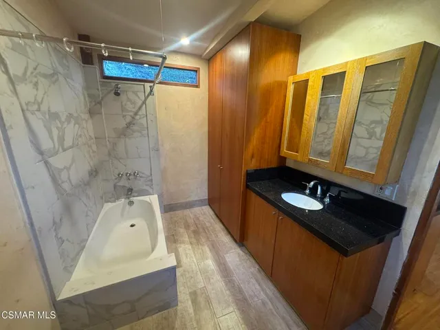 a bathroom with a sink vanity granite and shower