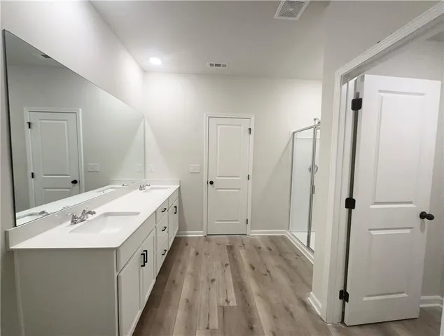 a spacious bathroom with a double vanity sink and mirror