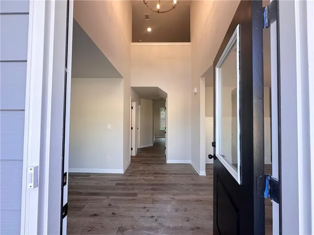 a view of a hallway with wooden floor and staircase