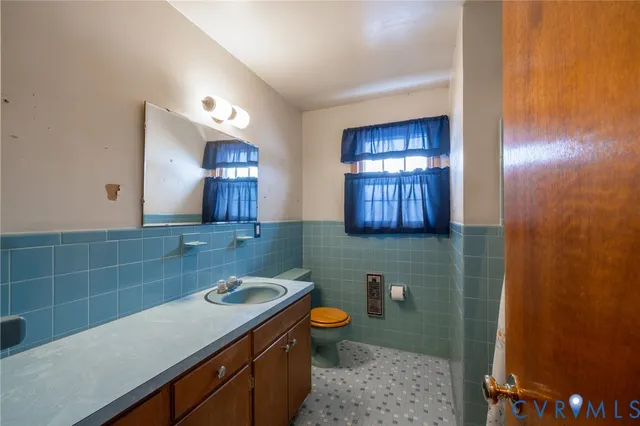 a bathroom with a sink a toilet and mirror