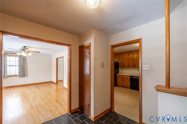 a view of a hallway with wooden floor and a living room