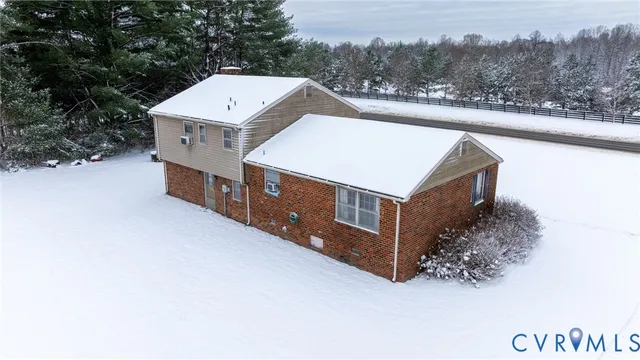 an aerial view of a house with a yard and large tree