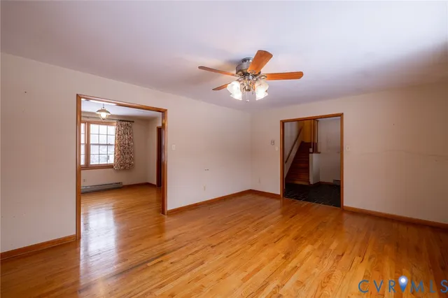 a view of a hallway with wooden floor and a ceiling fan