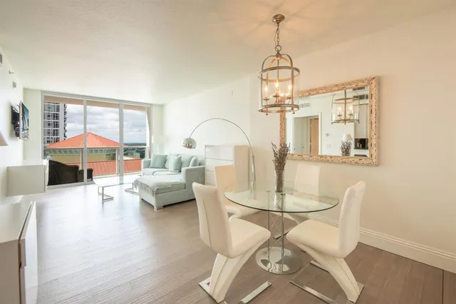 a living room with furniture a dining table and a chandelier