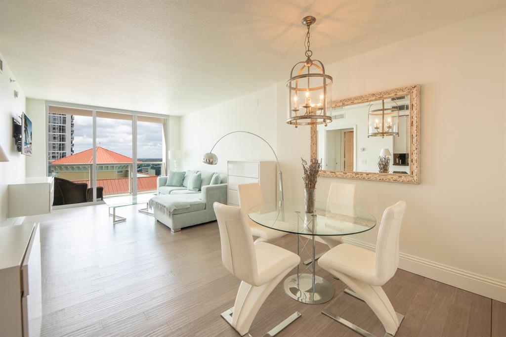 350 Southeast 2nd Street, Unit 1680 Fort Lauderdale, FL 33301 - Photo 2 of 35 a living room with furniture a dining table and a chandelier