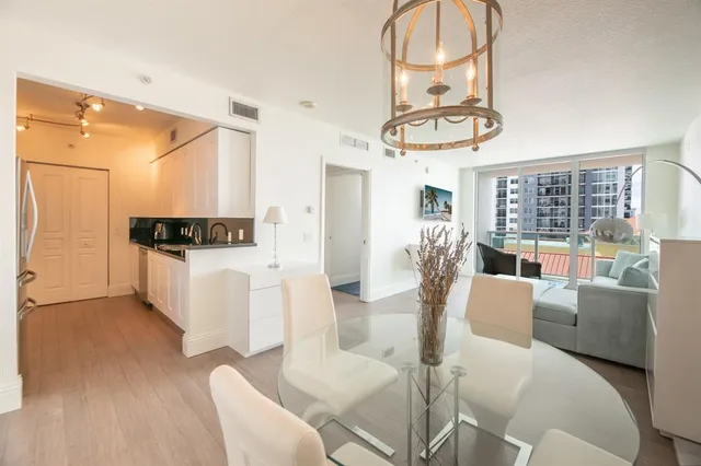 a living room with furniture a couch and large mirror with wooden floor