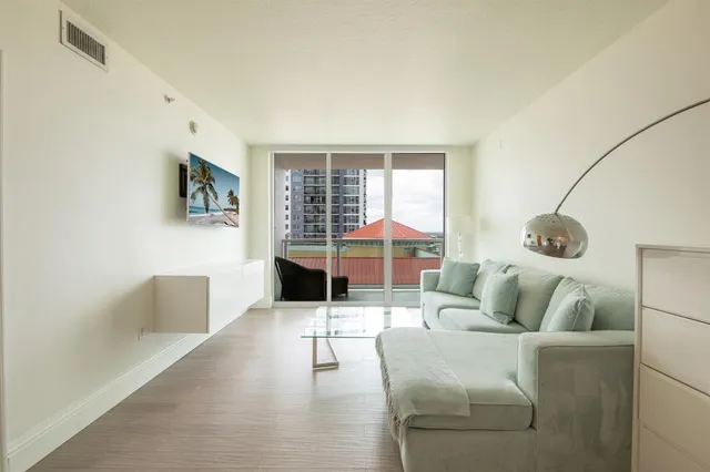 a living room with furniture and a floor to ceiling window