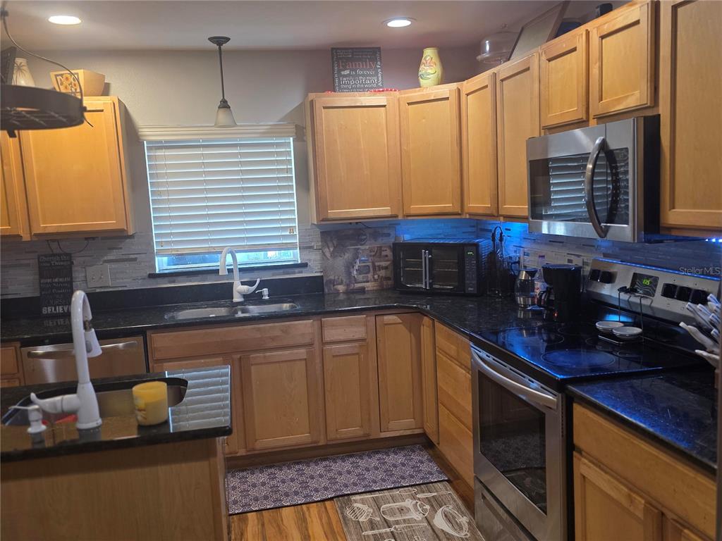 959 Thomas Road Eagle Lake, FL 33839 - Photo 11 of 35 a kitchen with stainless steel appliances granite countertop a sink stove and cabinets
